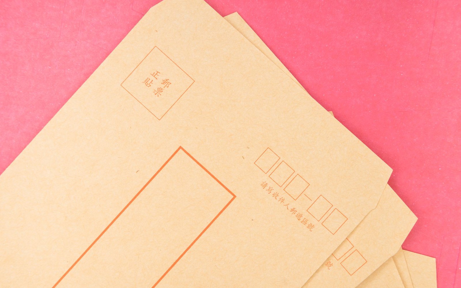 A Netflix red mailing envelope beside a DVD disc case on a wooden surface