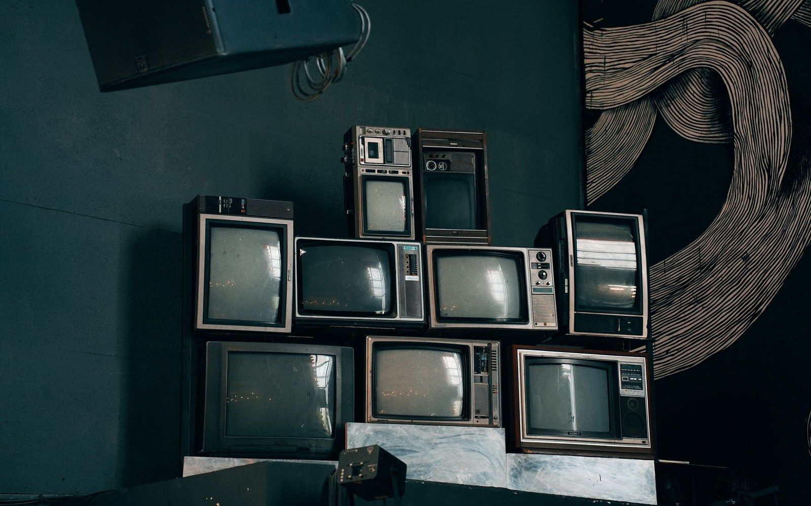 A 1990s cathode-ray television displaying a public-access channel card, in a living room setting